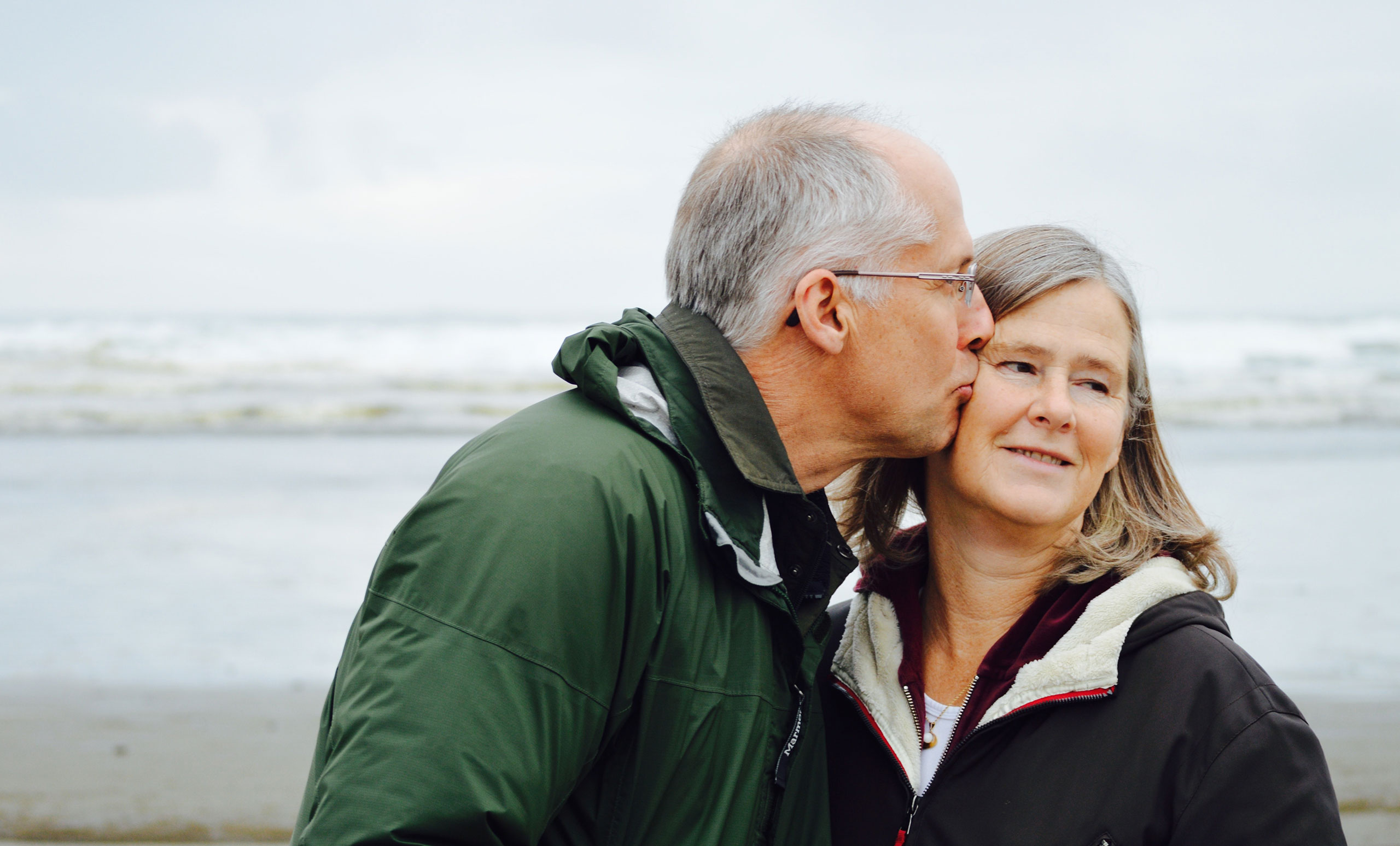 Aged Couple kissing on beach